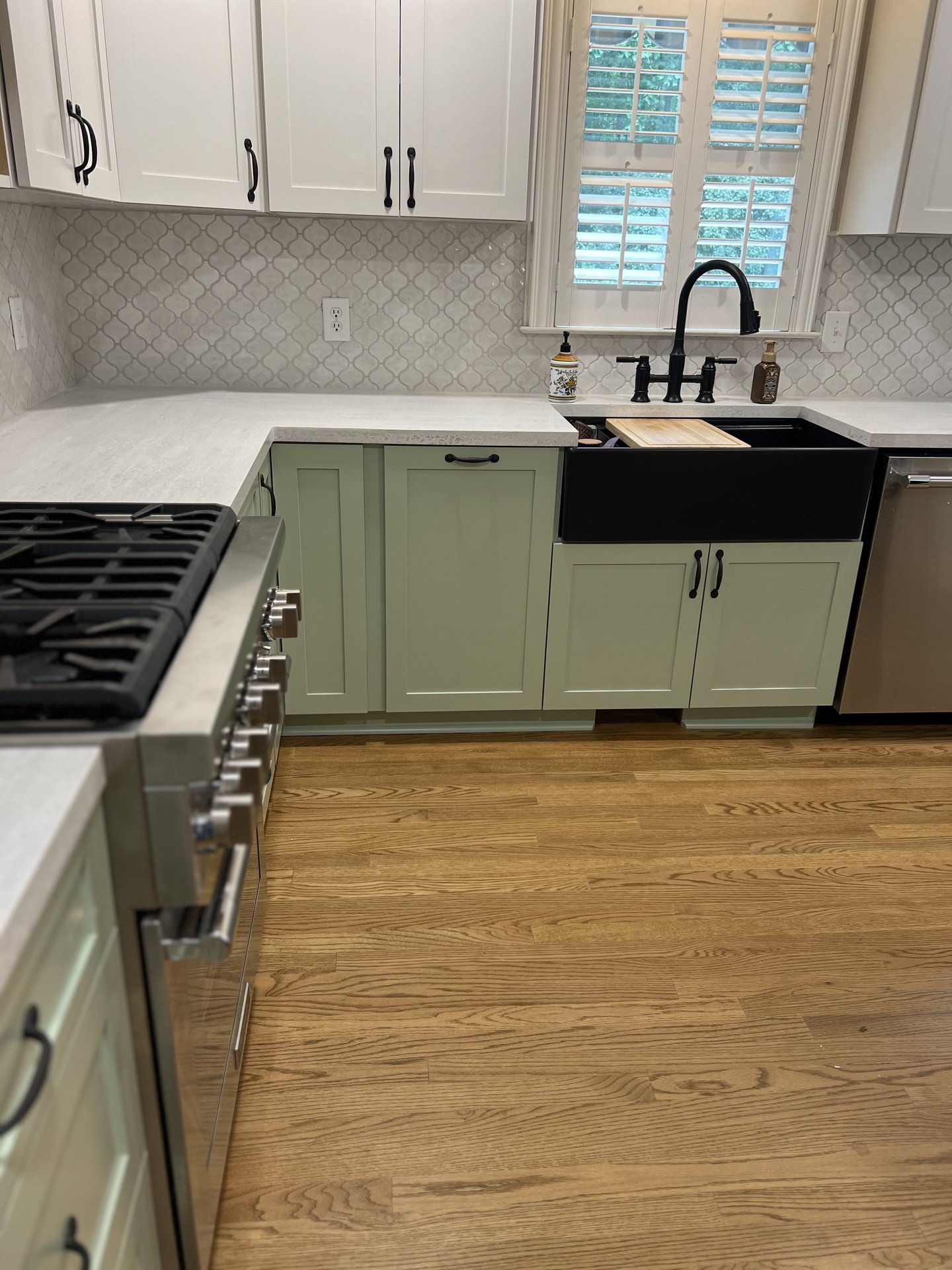 Two-tone sage green and white custom kitchen cabinetry