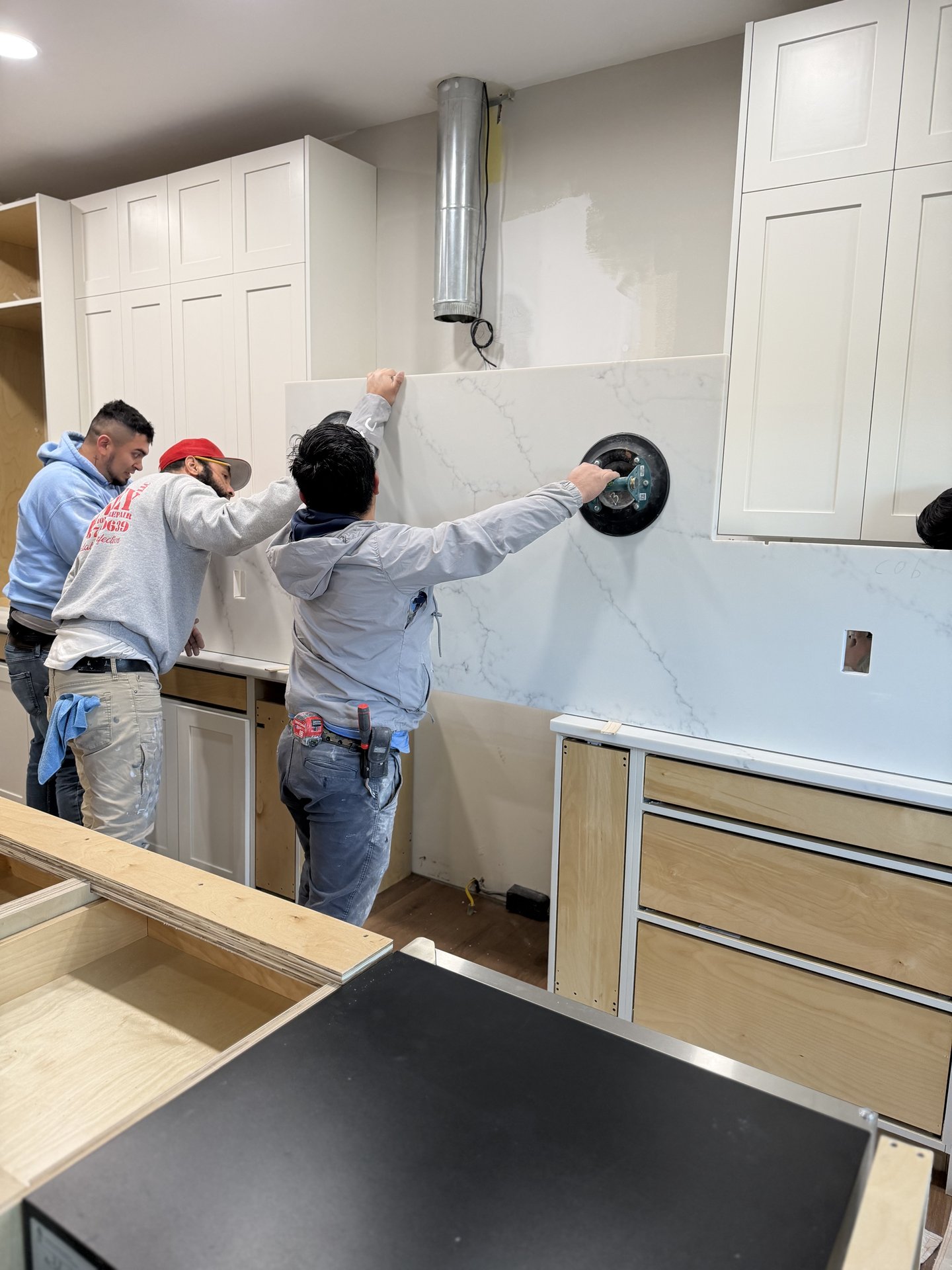 Crew installing quartz countertop slab